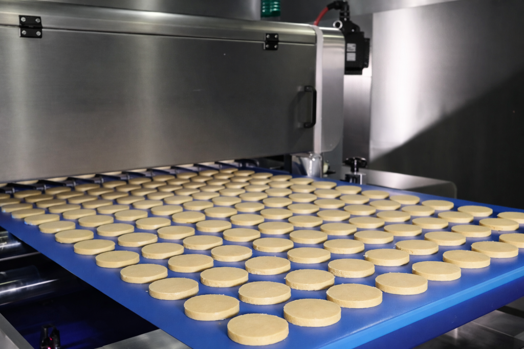Blue food grade PU conveyor belt transporting dough in automated bakery line by Nova Beltech