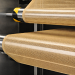 PTFE coated open mesh conveyor belt running on stainless steel rollers in heat drying system by Nova Beltech